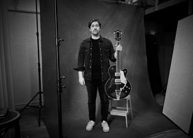 Zwart-wit foto van Alex Ploeg met een gitaar in zijn handen