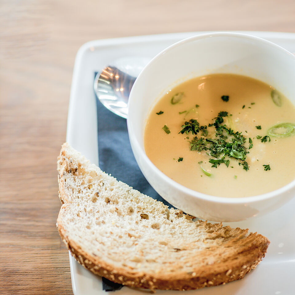 Een kop soep met brood erbij in het Lindenberg Café. 