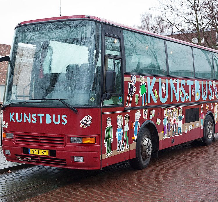 De kunstbus is een vrolijke rode bus met illustraties erop.