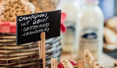 Op het buffet staat broodmand met broodjes en een bordje waarop gerechtjes geschreven staan
