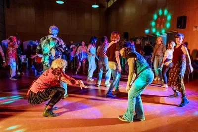 Groep mensen die danst op een kleurrijk verlichte dansvloer