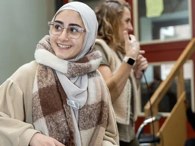 Een meisje draait geconcentreerd aan de knoppen van de DJ-set en straalt plezier uit