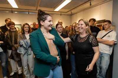 Jongere wordt emotioneel toegesproken tijdens een uitreiking in een volle ruimte