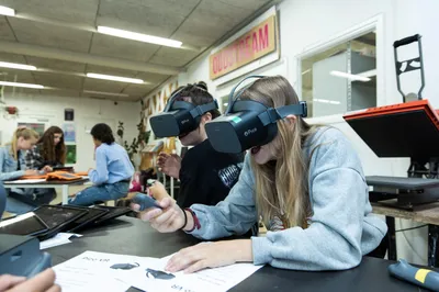 Jongeren gebruiken VR-brillen aan een tafel tijdens een creatieve workshop