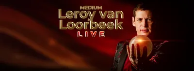 Een banner waarin met gouden letters de show aangekondigd wordt. Leroy staat er naast en kijkt indringend naar zijn glazen bol.