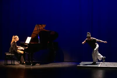 Pianist speelt terwijl een danser solo danst op een klein verhoogd vlak.