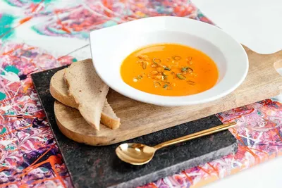 Een bord heldere soep met twee sneetjes brood ernaast