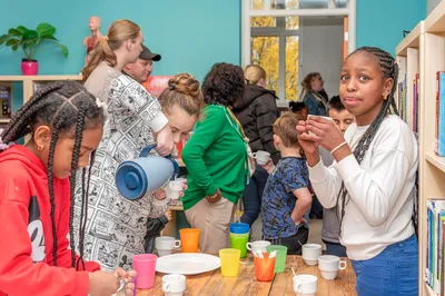 Kinderen schenken vrolijk drinken in een klas vol gezellige beweging