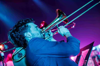 Een foto van een man die vol passie zijn trompet bespeelt. 