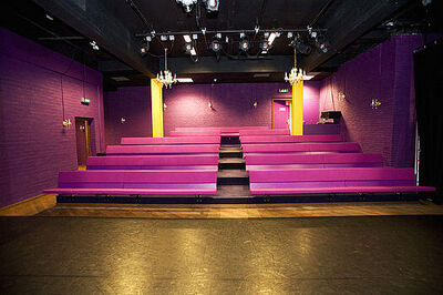 Een lege zaal met paarse stoelen