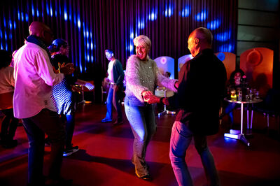 Man en vrouw die dansen tussen kleurrijke lichteffecten