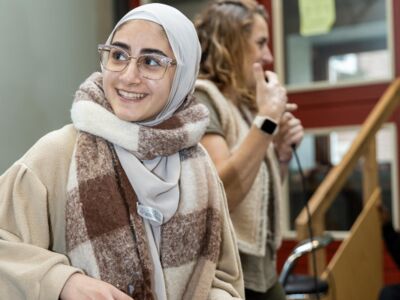 Een meisje draait geconcentreerd aan de knoppen van de DJ-set en straalt plezier uit