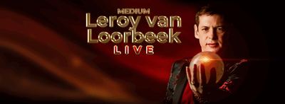 Een banner waarin met gouden letters de show aangekondigd wordt. Leroy staat er naast en kijkt indringend naar zijn glazen bol.