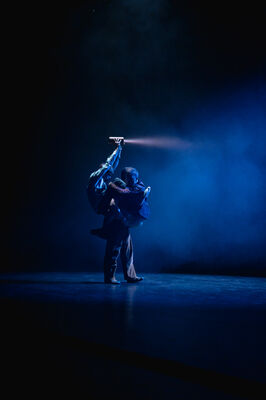 Een man zit op de rug van een andere man en schijnt angstig in de mist met een zaklamp om zich heen.