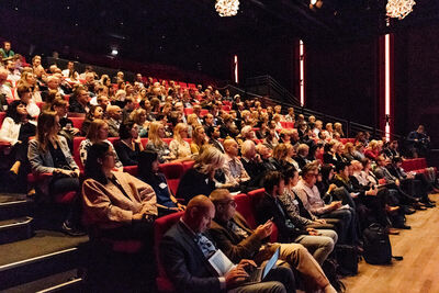 Beeld van publiek op de vol bezette tribune van de Lindenbergzaal