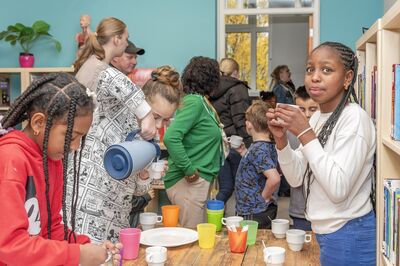 Kinderen schenken vrolijk drinken in een klas vol gezellige beweging