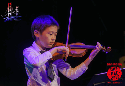 Jonge violist speelt viool op het podium tijdens een muziekoptreden.