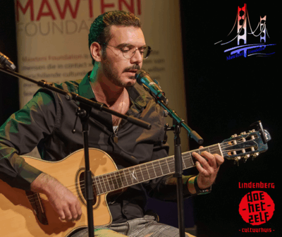 Muzikant zingt en speelt gitaar tijdens optreden van Mawteni Foundation.
