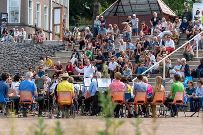 Orkest speelt voor een volle tribune met publiek bij Podium aan de Waal.