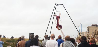 Publiek kijkt naar luchtacrobaten die hoog in een constructie optreden aan de Waal.