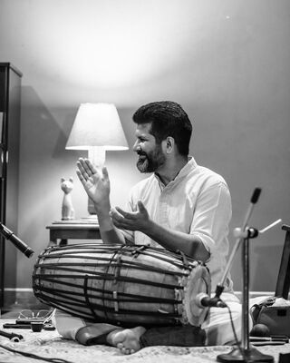 Een zwart-wit foto van een man die een slaginstrument bespeelt. 